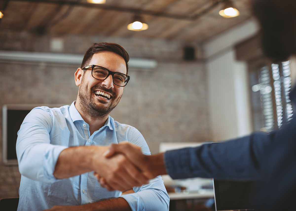 Business professional greeting a client in a modern office
