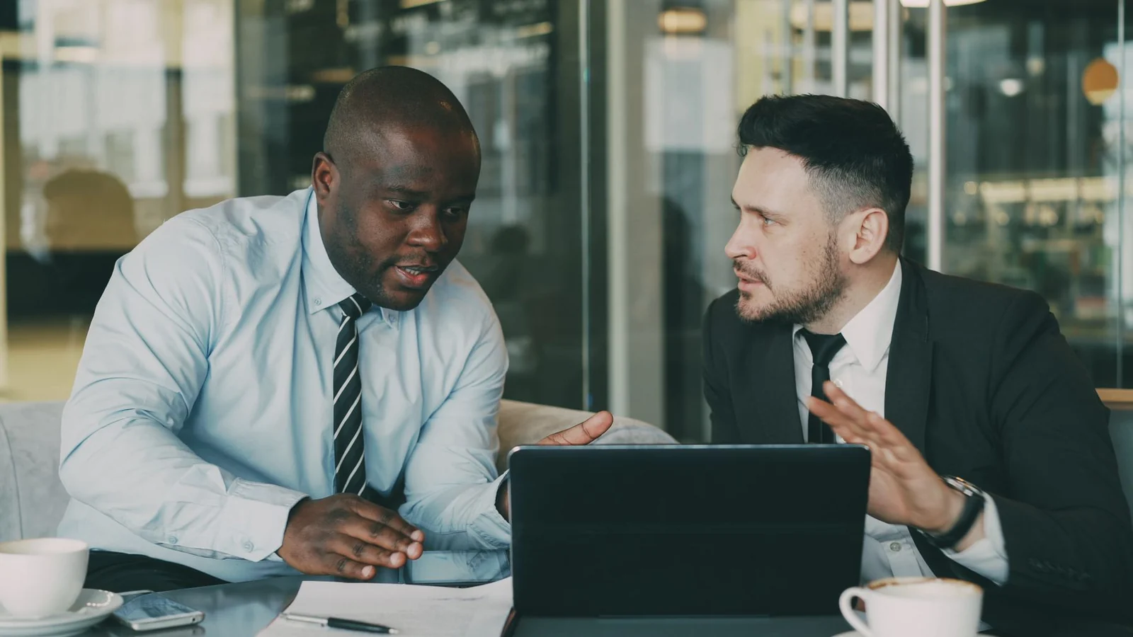 Financial services professionals discussing strategy on a laptop