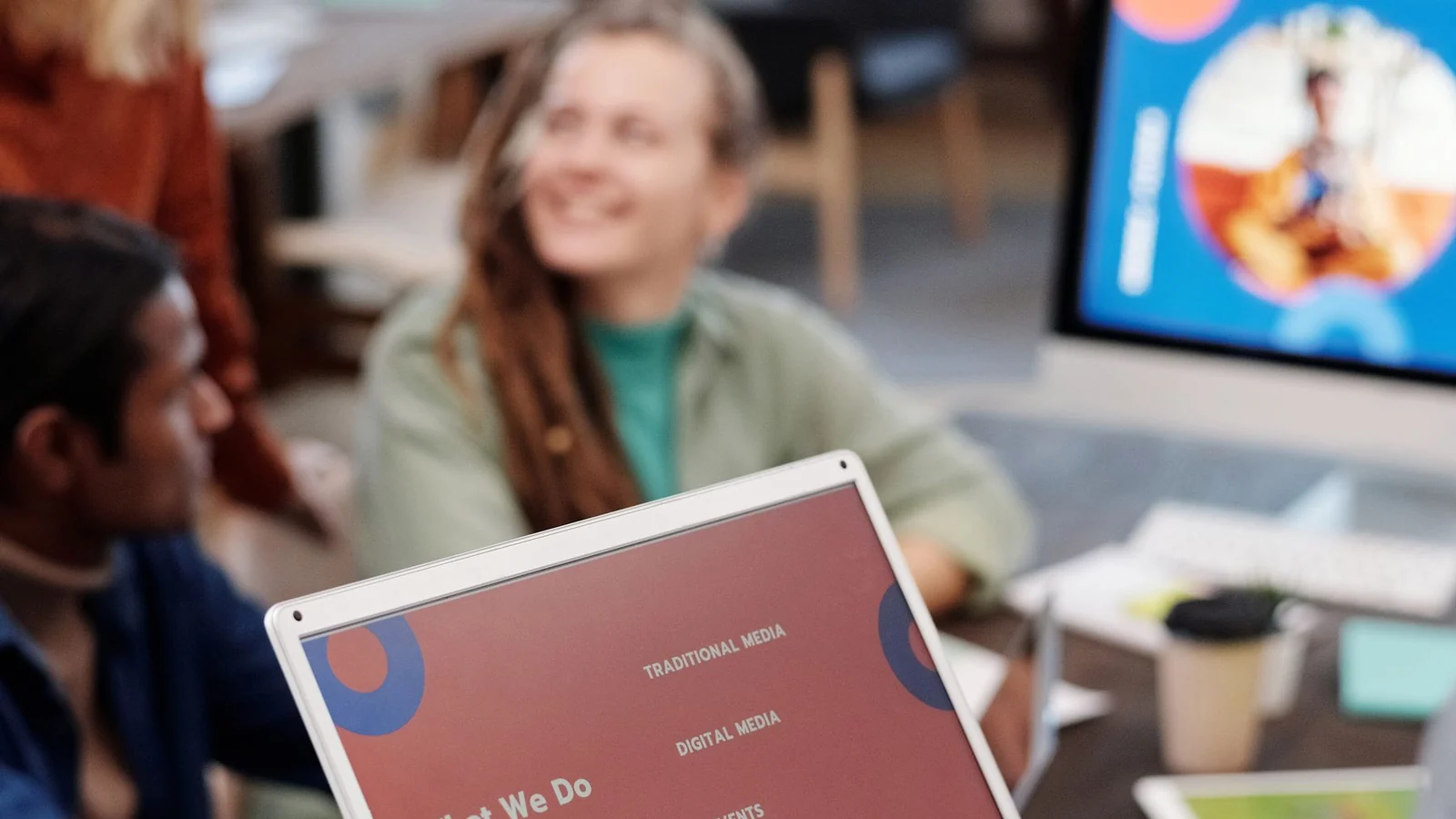 Small marketing team planning a campaign around a laptop